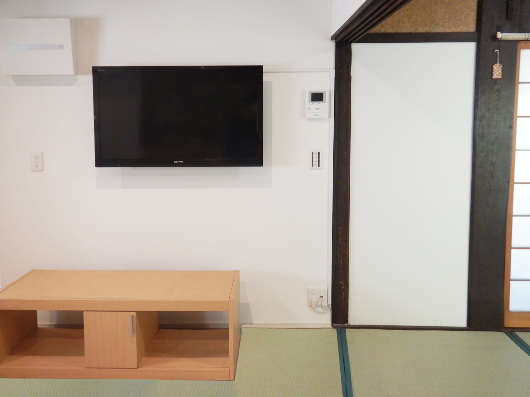 ダイニング　キッチン横のダイニングには別部屋にあった壁掛けテレビを取り付け、その横には防犯のためのモニターホンも設置しました。